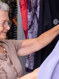 Shopper holding up a lavender top at Sister's Closet