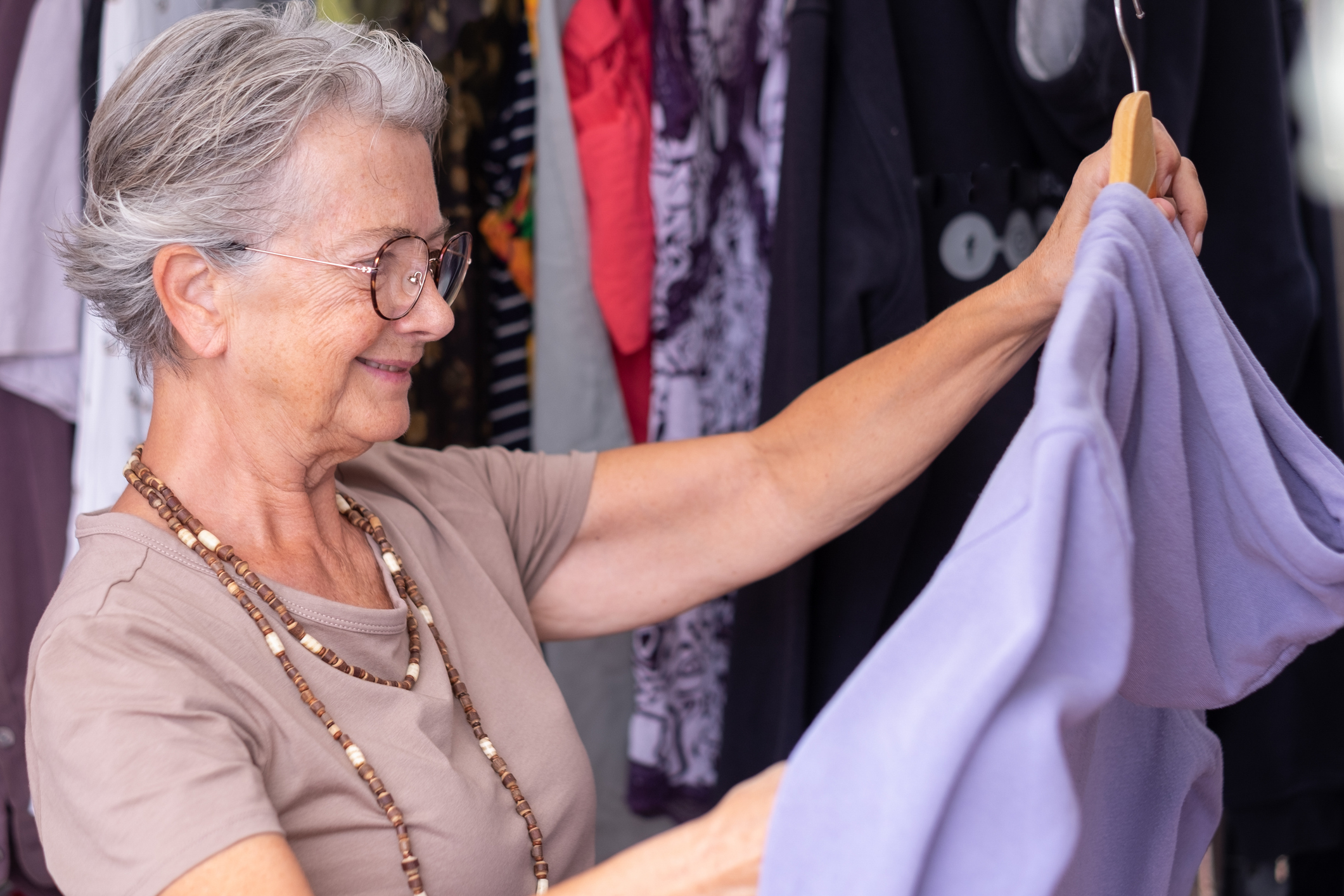 Shopper smiling while holding up a lavender top